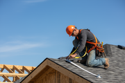 Construction worker using white safety strap on roof